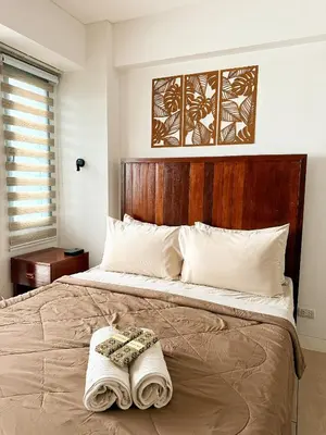 a bedroom with a large bed with a wooden headboard at Kai cabins NEAR NAIA 3 SELF CHECK IN AT NEWPORT CITY in Manila