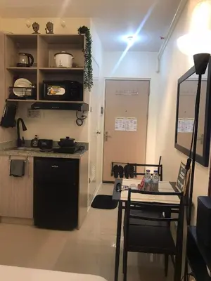 a kitchen with a counter and a table and a table and chairs at InMer's D Staycation in Manila