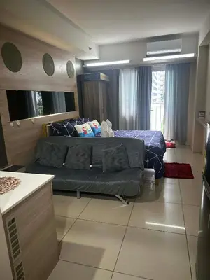 a bedroom with a bed and a couch in it at AJ Staycation in Manila