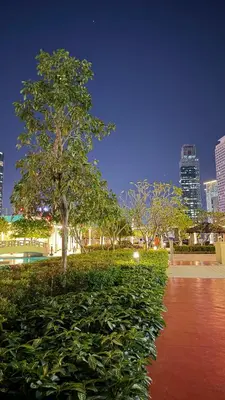 a park with a tree and bushes in a city at Jazz Staycation Makati By As in Manila