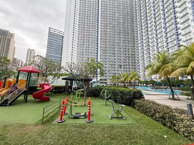 a park with a playground with a slide and swings at Jazz Staycation Makati By As in Manila