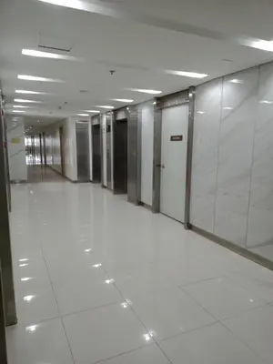 a hallway of an office building with white tile floors at 1 Bedroom Apartment with Mountain View and WiFi in Manila