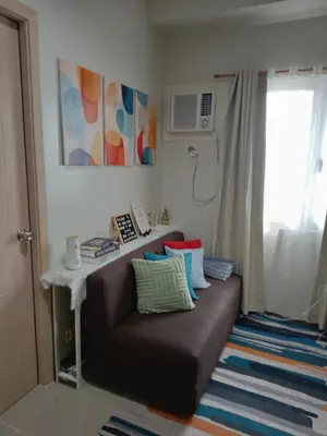 a couch with pillows on it in a room at 1 Bedroom Apartment with Mountain View and WiFi in Manila