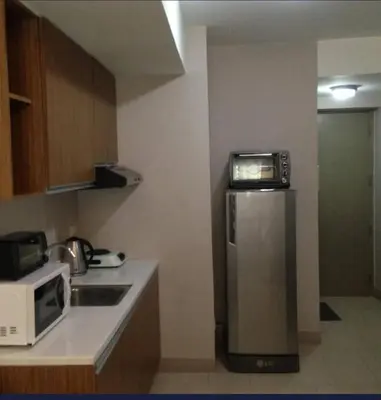 a small kitchen with a refrigerator and a microwave at Luxury 2BR Condo in Makati Near Malls & Offices in Manila