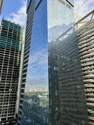 a tall glass building with a view of a city at The Gramercy Residences in Manila