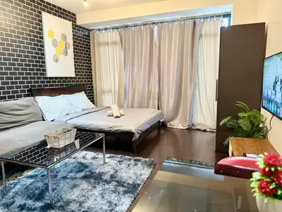 a living room with a bed and a couch at The Gramercy Residences in Manila