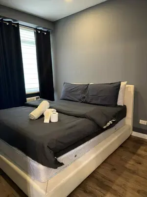 a bedroom with a bed with two candles on it at The Gramercy Residences in Manila