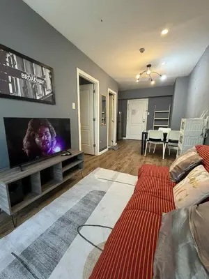 a living room with a large flat screen tv at The Gramercy Residences in Manila