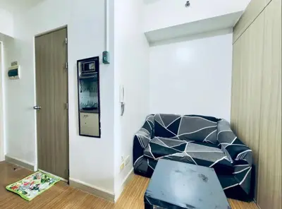 a living room with a couch and a mirror at Room for Rent in Manila
