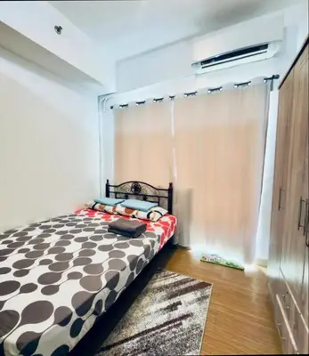 a bedroom with a black and white bed and a window at Room for Rent in Manila