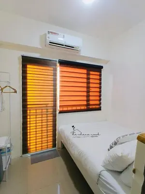 a bedroom with a bed and a window with blinds at The Ohana Nook in Manila