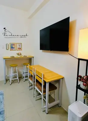 a dining room with a table and a television on a wall at The Ohana Nook in Manila