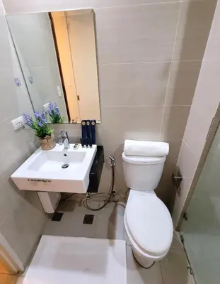a bathroom with a toilet and a sink at Urban Studio with Balcony in Manila