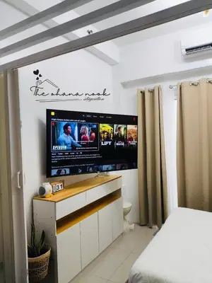 a bedroom with a flat screen tv on the wall at The Hearth Bliss in Manila