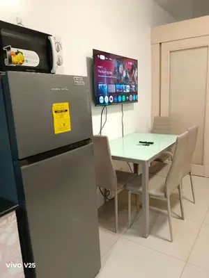 a dining room with a table and a refrigerator at Sea residences Sweetest escape in Manila