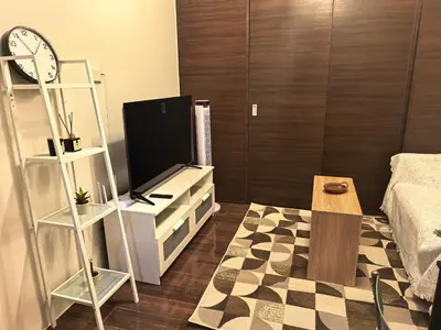 a living room with a tv and a table at Pine3s Turf in Manila
