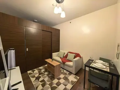 a living room with a couch and a table at Pine3s Turf in Manila