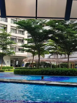 a person swimming in a pool in front of a building at SMDC Grace Residences Tower 4 in Manila
