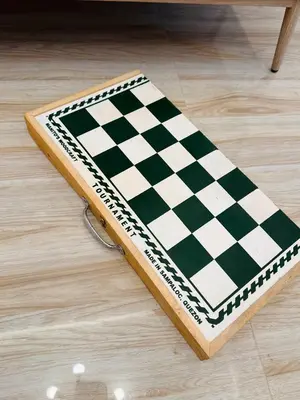 a black and white chess board on a wooden floor at PPL Homestay