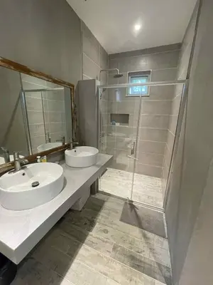 a bathroom with two sinks and a shower at Pleasant Hill Cabins near Tagaytay Highlands