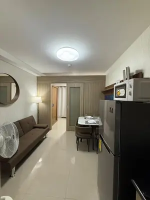 a kitchen and living room with a couch and a table at The Grand Haven at Shore Residences in Manila