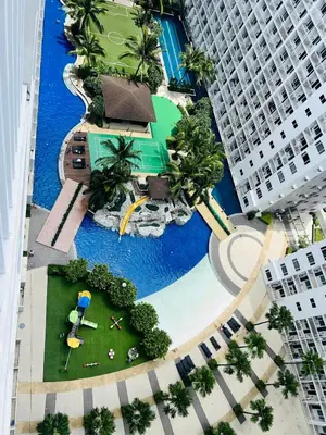 an overhead view of a resort swimming pool with buildings at The Sunset Cozy Suite at Shore 1 in Manila