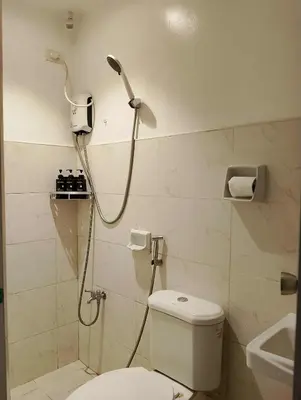 a bathroom with a shower with a toilet and a sink at Modern 2 Storey 2BR Home with 2 Parking Space in Manila