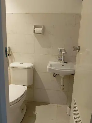 a white bathroom with a toilet and a sink at Modern 2 Storey 2BR Home with 2 Parking Space in Manila