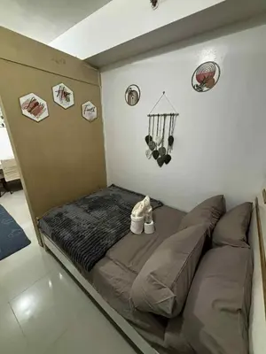 a small bed in a room with signs on the wall at Sea Residence Condotel Tower E&F in Manila