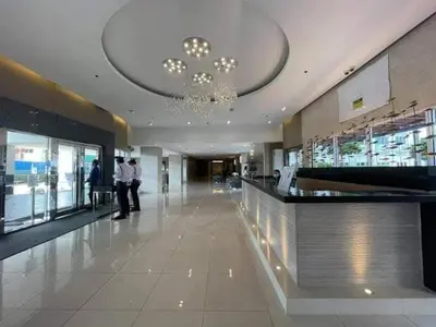 two people standing in a lobby of a building at Sea Residence Condotel Tower E&F in Manila