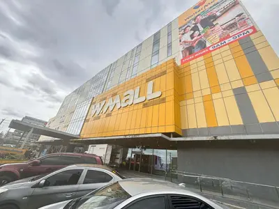 a large building with cars parked in a parking lot at Vera's Place in Mall of Asia Complex in Manila