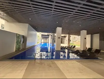 a large lobby with a swimming pool in a building at Vera's Place in Mall of Asia Complex in Manila