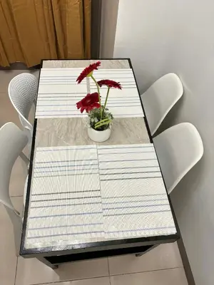 a table with red flowers in a vase on it at Vera's Place in Mall of Asia Complex in Manila
