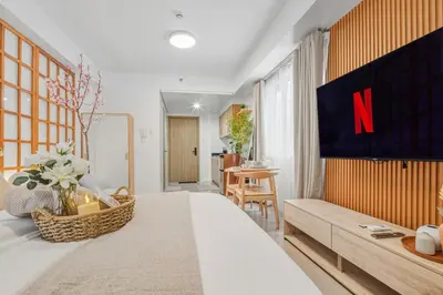 a bedroom with a large bed with a n on the wall at Japandi Aesthetic Corner Unit, Calm & Private, MOA in Manila