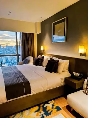 a hotel room with a large bed and a window at DE LUX SUITE at Novotel Manila Hotel Residences Acqua in Manila