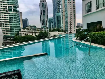 a large swimming pool in a city with tall buildings at DE LUX SUITE at Novotel Manila Hotel Residences Acqua in Manila