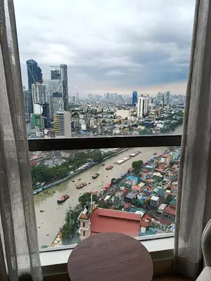 a view of a city skyline from a window at DE LUX SUITE at Novotel Manila Hotel Residences Acqua in Manila