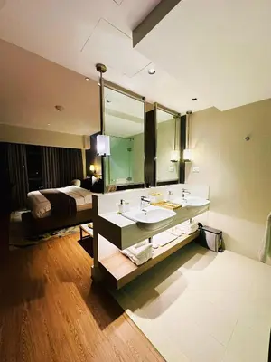 a bathroom with a sink and a bed in a room at DE LUX SUITE at Novotel Manila Hotel Residences Acqua in Manila