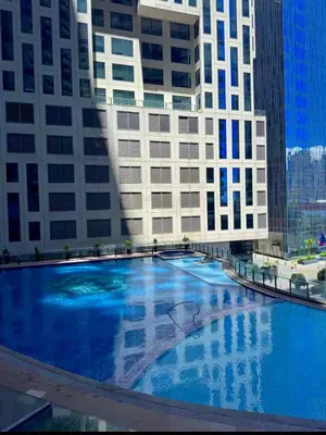 a large blue swimming pool in front of a building at Cozy Studio Unit at The Knightsbridge Residences in Manila