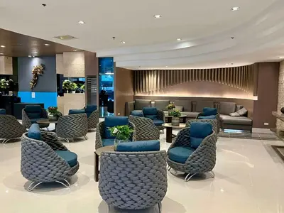 a lobby with a waiting room with blue chairs at Pit Stop Haven Near Manila Airport and Mall of Asia in Manila