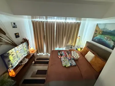 a small room with a bed and a large window at Casa Maria urban resort in Manila