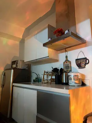 a kitchen with white cabinets and a stainless steel refrigerator at Casa Maria urban resort in Manila