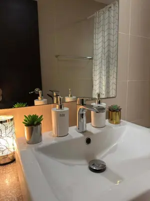 a bathroom sink with two faucets and a mirror at The Verdin Sweet at Maple Grove Gen Tri Cavite in General Trias