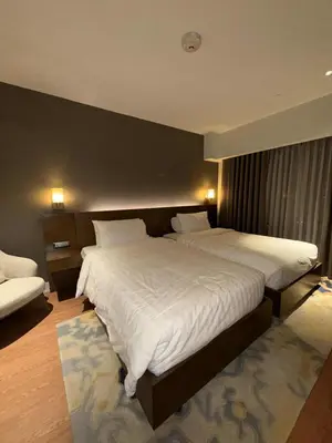 a bedroom with two beds with white sheets at Novotel at Acqua, The Hotel Residences by RM in Manila