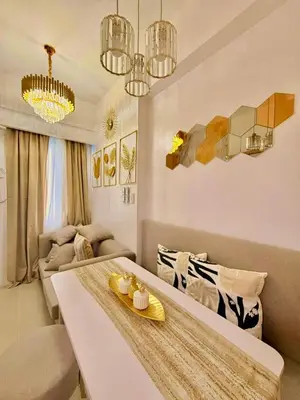 a living room with a table and a couch at Golden Maison de Luxe in Manila