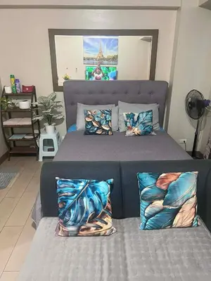 a bedroom with a large bed with pillows on it at Vevilyn Nariz in Manila