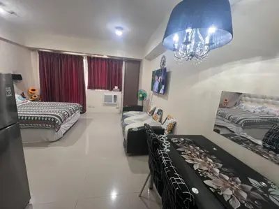 a bedroom with two beds and a chandelier at Vevilyn Nariz in Manila