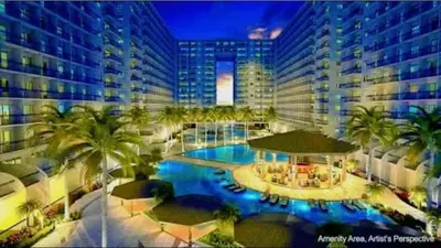 a large building with a pool with palm trees and buildings at Maggielyn Jacob Place in Manila