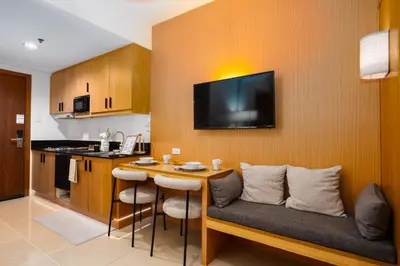 a living room with a couch and a table with chairs at Brand New Japandi - Modern 1 BR Walk to MOA in Manila