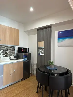 a kitchen and dining room with a table and chairs at Condo near airport - azure residences in Manila
